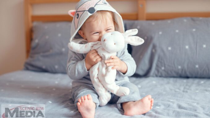 Portrait of cute adorable Caucasian blonde smiling baby girl wit
